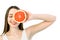 Portrait of young beautiful woman with healthy perfect skin holds piece of grapefruit, closing one eye. Skincare, facial