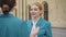 Portrait of young beautiful woman in stewardess uniform talking with coworker outdoors. Positive smiling Caucasian lady