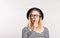 Portrait of a young beautiful woman in studio, putting finger on her mouth.