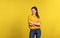 Portrait of a young beautiful woman in studio on yellow background.