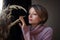 Portrait of a young beautiful woman touching wheat spikelets. Blonde girl wearing pink sweater in scandinavian interior