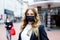 Portrait of young beautiful woman wearing medical mask as protection against corona virus. Covid pandemic time in Europe