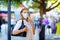 Portrait of young beautiful woman wearing medical mask as protection against corona virus. Woman shopping in the city