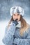 Portrait of young beautiful woman in winter clothes and strong snowing