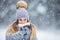 Portrait of young beautiful woman in winter clothes and strong snowing