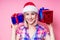Portrait of young Beautyful blond amazed woman with christmas box gift on red background. lady in a plaid shirt and