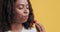 Portrait of young black woman eating fresh strawberry