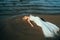 Portrait of young blond bride lies on sand among the water