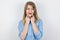 Portrait of young blond upset woman fixing her lips up with fingers pretending happy on isolated white background, body language