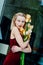 Portrait of the young blonde attractive woman with the iris flowers behind the glass