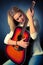 Portrait of young blonde guitar player woman