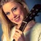 Portrait of young blonde guitar player woman