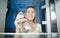 Portrait of young blonde woman feeling hungry taking bottle of water from refrigerator at night