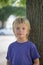 Portrait of a young boy in front of a tree