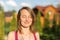 Portrait of young brunette caucasian woman smiling with closed eyes outdoors. Golden hour sunlight at sunset. Gree