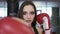 Portrait of a young brunette girl with boxing gloves.