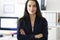 Portrait of young brunette woman in business suit in office