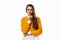 Portrait of young brunette woman keeping finger at her mouth, saying Shh, Hush, Tsss. Studio shot, white background