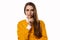 Portrait of young brunette woman keeping finger at her mouth, saying Shh, Hush, Tsss. Studio shot, white background