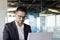 Portrait of a young business man, an entrepreneur who sits in a suit in the office at the table and concentrates on