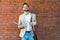 Portrait of young business man outside office building in the alley with brick wall background standing and thinking of solving