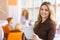 Portrait of young business woman at modern startup office interior, team in meeting in background