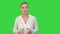 Portrait of a young business woman presenting something by a hand on a Green Screen, Chroma Key.