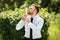 Portrait of young businessman kissing gold trophy cup in park