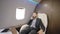 Portrait of young businessman lawyer talking on phone in luxury private jet.