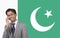 Portrait of young businessman using cell phone over Pakistani flag
