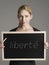 Portrait of young businesswoman holding blackboard with French text libertÃ© (freedom)