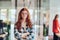 A portrait of a young businesswoman with modern orange hair captures her poised presence in a hallway of a contemporary