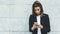 Portrait young businesswomen in black suit using smartphone isolated on background concrete gray wall mockup, hipster manager