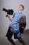 Portrait of a young cameraman with old movie camera and a suitcase in his hand