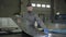 Portrait of young Caucasian foreman checking steel metal sheet. Handsome man in working gloves holding ready production