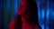 Portrait of a young caucasian girl neon darkness blue background night shadow red light enjoys