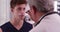 Portrait of young caucasian sports athlete having eyesight checked by doctor