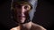 Portrait of a young caucasian topless male tired boxer, in boxing helmet, head guard, looking into camera, black