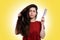Portrait of a young caucasian woman holding her thick dark hair and comb for combing. White background. Hair care concept