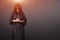 Portrait of a young caucasian woman praying. Prayer girl dressed in Vestments of a nun on gray studio background