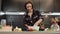 Portrait of young cheerful woman cooking dinner for family in domestic kitchen. Female knead dough in bowl, preparing pizza. Hands