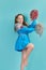 Portrait of young cheerleader girl from cheerleading group. turquoise background