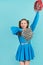 Portrait of young cheerleader girl from cheerleading group. turquoise background