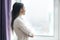 Portrait of young confident businesswoman in white shirt with arms crossed, woman looking out the window, office in skyscraper