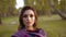 Portrait of a young confident girl looks at camera in sunny park