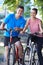 Portrait Of Young Couple Cycling Next To River In Urban Setting