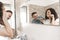 Portrait of a young couple having fun while brushing their teeth in front of the bathroom mirror - concept of complicity and