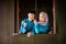 A portrait of young couple of malay muslim in traditional costume during Aidilfitri celebration at the wooden window of