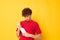 portrait of a young curly man detergents home care posing yellow background unaltered