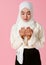 Portrait of young and cute Asian Islamic woman rise hands in praying gesture in calm and concentrate manner